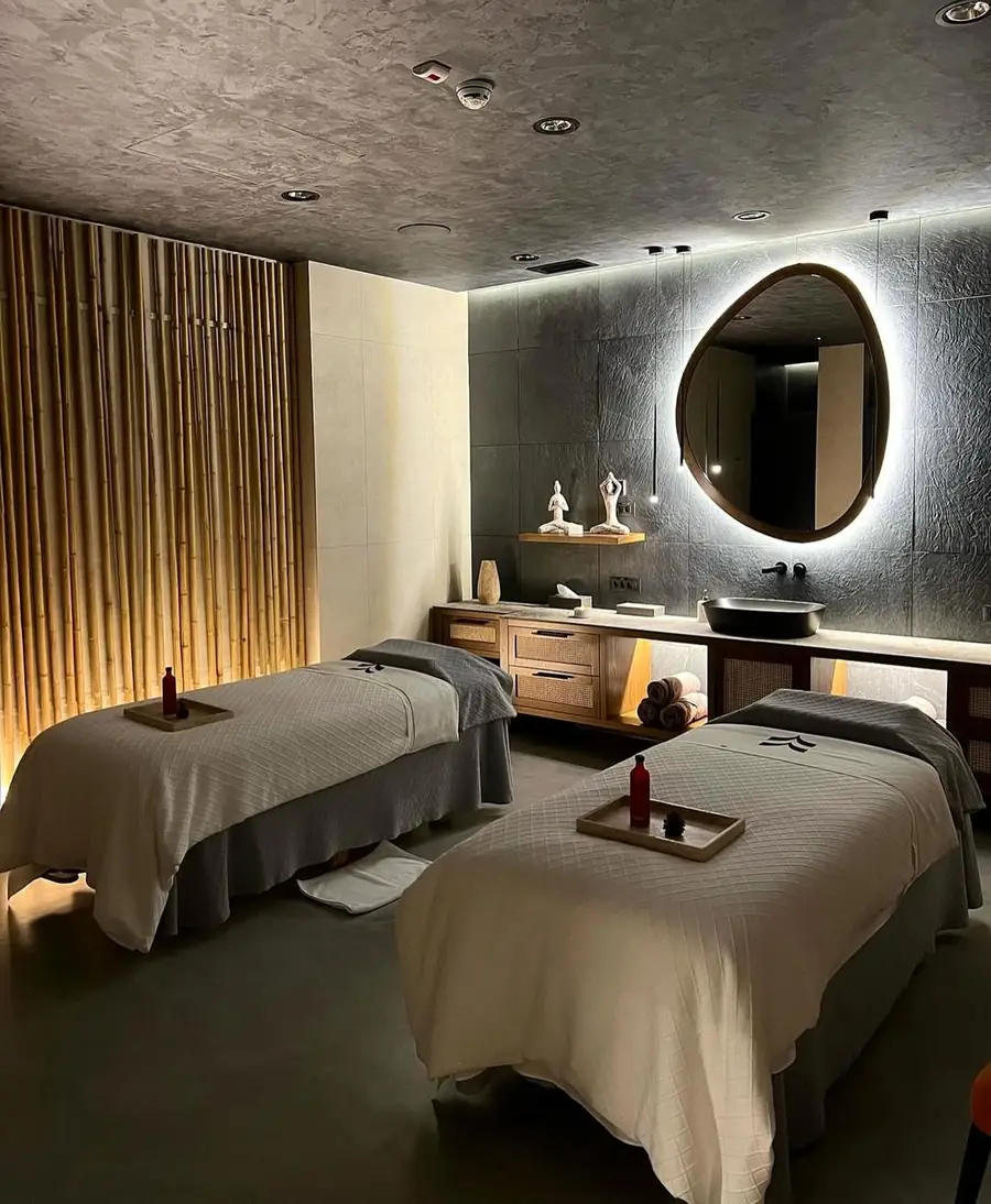Two massage beds in a dim, candle-lit room at Olive Wellness Spa